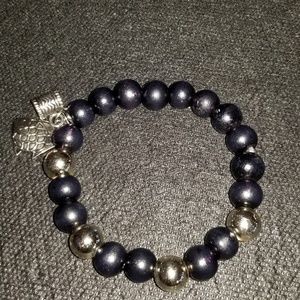 Silver and black bracelet with two silver charms.